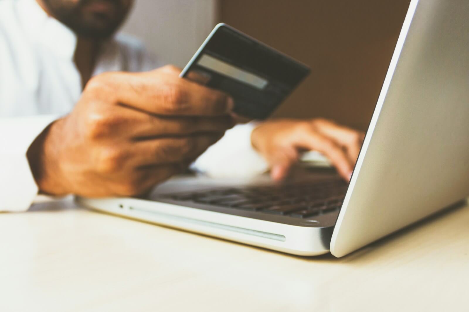 Hands comparing multiple crypto platform interfaces displayed on computer monitors