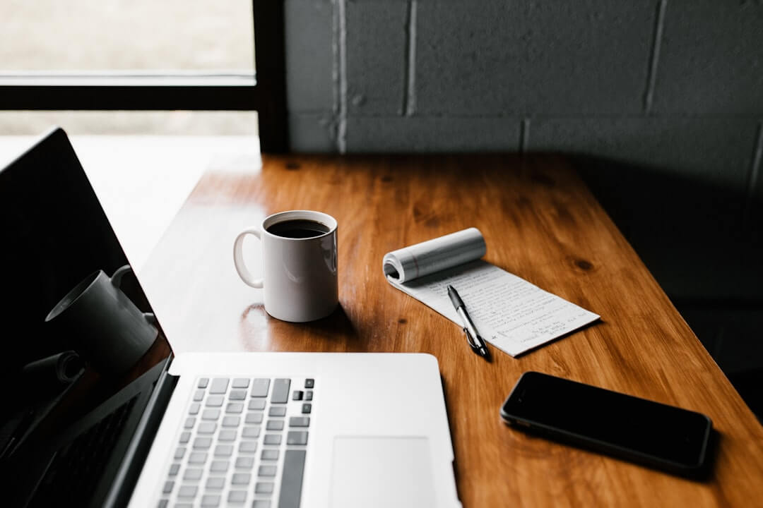 Person scrutinizing crypto investment app on smartphone at desk with research papers